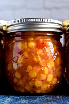 three jars filled with food sitting on top of a table