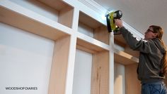 a woman is using a power drill on the wall