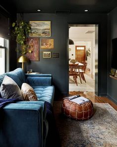 a living room with blue couches and pictures on the wall above it's doorway