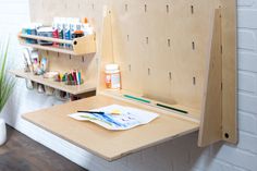 an easel is sitting on the wall next to some paintbrushes and other art supplies