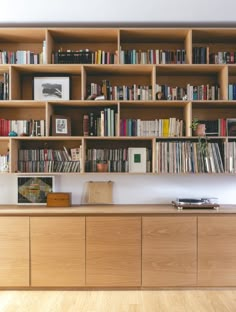 a bookshelf filled with lots of books on top of wooden shelves