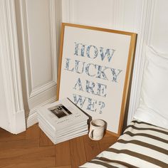 a stack of books sitting on top of a wooden floor next to a framed poster