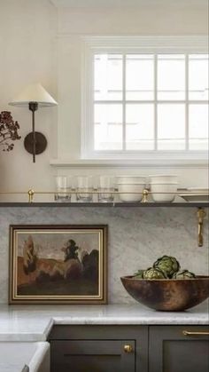 an image of a kitchen setting with pictures on the wall and below it is a bowl full of vegetables