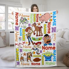 a woman holding up a blanket with cartoon characters on it