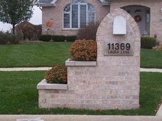 a brick house with landscaping in front of it