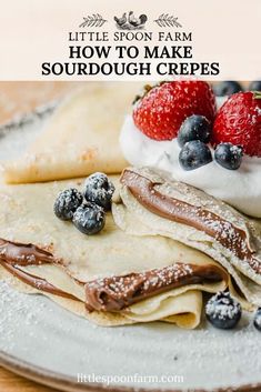 a plate topped with pancakes covered in whipped cream and strawberries next to blueberries