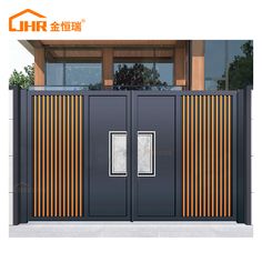 an image of a modern steel gate with orange and black stripes on the side, in front of a building