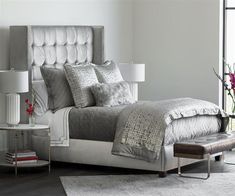 a large bed sitting next to a window with flowers on top of it in a bedroom