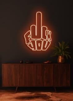 a neon sign that is on the side of a cabinet in front of a black wall