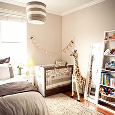 a baby's room with a giraffe statue in the corner