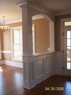 an empty living room with hard wood flooring and white trim on the fireplace mantel