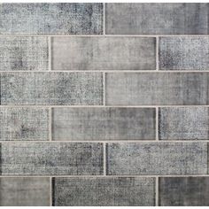 a gray brick wall that has been made out of different shades of grey and white