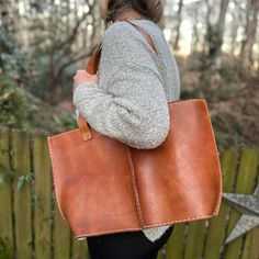 Intertwined's luxe seamed leather tote is crafted with thick, supple cow's leather. It offers an inside zippered pocket, one inside slip pocket, plus a full zippered closure. Customers rave about how versatile this multi-purpose bag is--it's being used as an all-in-one purse, and also as a daily laptop/work bag. Plus, the contrasting white stitching adds just the right touch of character and confirms that it was stitched by skilled artisans. Take this classic tote wherever you want to go--it's s Fall Leather Lined Tote Shoulder Bag, Natural Soft Leather Shoulder Bag, Large Soft Leather Shoulder Bag, Rectangular Shoulder Bag With Leather Lining For Fall, Large Leather Shoulder Bag For Errands, Fall Rectangular Shoulder Bag With Leather Lining, Fall Tote Shoulder Bag With Leather Backing, Leather-lined Tote Bag For Fall, Fall Tote Bag With Leather Lining