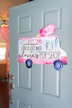 a door with a pink ice cream truck painted on it and balloons in the background