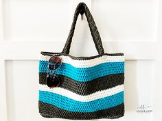 a crocheted bag hanging from a hook on a white door with sunglasses in it