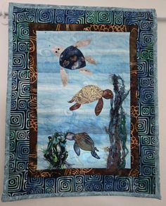 a quilted wall hanging with sea turtles and other marine creatures on it's side