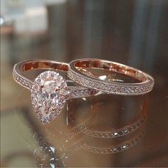 two wedding rings sitting on top of a table next to each other with diamonds in them