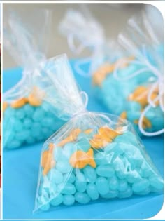 three bags filled with blue and yellow candies sitting on top of a table next to each other