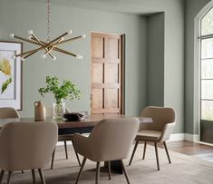 a dining room table with beige chairs and a chandelier