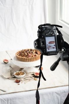 a camera attached to a tripod with food in the background