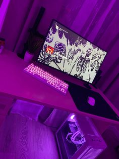 a desk with a computer and keyboard lit up in purple light on top of it