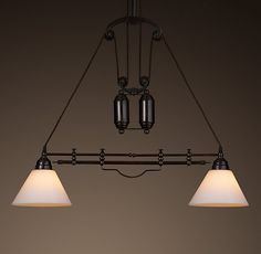 three lights hanging from a ceiling fixture in a room with dark walls and flooring