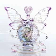 a glass vase with flowers in it on a white surface and an angel figurine