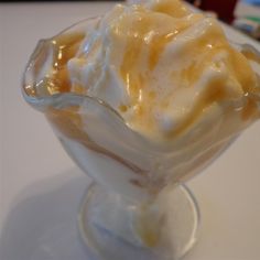 a small glass bowl filled with ice cream on top of a white tablecloth covered table