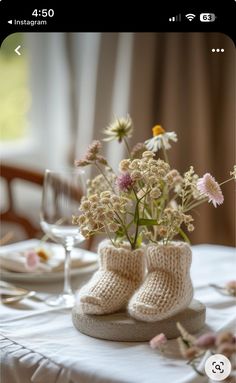 a pair of baby shoes sitting on top of a table with flowers in the middle