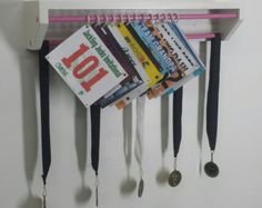 there is a green rack with scissors and magazines hanging from it's hooks on the wall