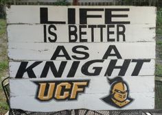 a sign that says life is better as a knight ucf on the side of a fence