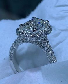 a fancy diamond ring sitting on top of a white sheet covered in snow and ice