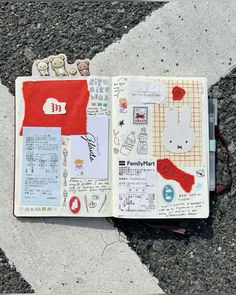 an open notebook with stickers on it sitting on the ground next to a street