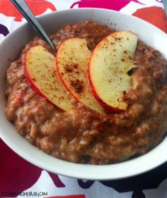 a bowl filled with oatmeal topped with sliced apples