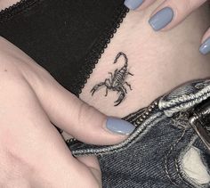 a scorpion tattoo on the side of a woman's stomach is shown in this image