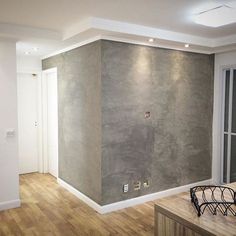 an empty room with wood floors and gray walls