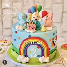 a birthday cake decorated with animals and balloons