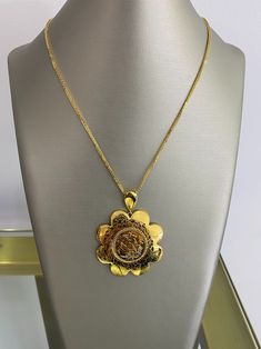 Embrace the enchantment of our 21K Gold Pendant, a delicate flower-shaped masterpiece. Imbued with an embedded horse rider insignia, it embodies a harmonious blend of elegance and adventurous spirit. Let this captivating pendant adorn your neckline, a symbol of exquisite taste and a timeless reminder of grace and daring. Luxury Filigree Medallion Necklaces, Luxury Filigree Medallion Necklace, Luxury Filigree Round Pendant Necklace, Elegant Yellow Gold Medallion Necklace With Large Pendant, Luxury 22k White Gold Necklaces, Luxury Necklaces With Intricate Medallion Design, Luxury Gold-plated Pendant Medallion Necklace, Luxury Filigree Medallion Jewelry, Luxury Medallion Jewelry With Filigree