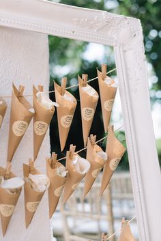 an ice cream cone garland is hanging from a white frame with paper cones attached to it