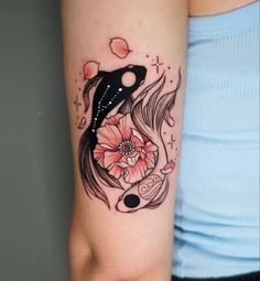 a woman's arm with a fish and flower tattoo design on her left arm