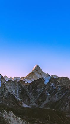 the mountains are covered in snow at sunset