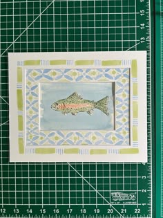 a drawing of a fish sitting on top of a cutting board next to a ruler