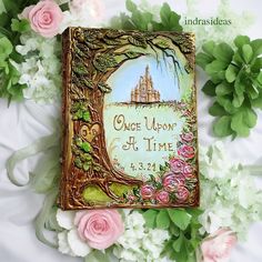 there is a book with an image of a castle on it and flowers around it