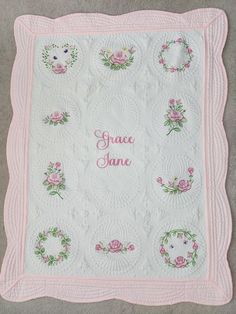 a pink and white quilt with flowers on it that says grace jane in the center