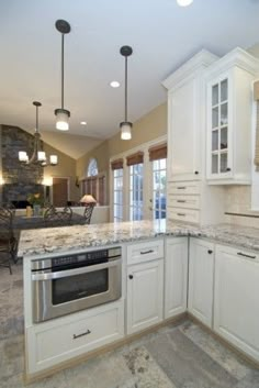 a large kitchen with white cabinets and granite counter tops, along with marble flooring