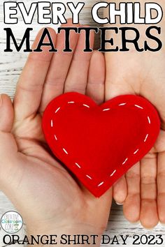 a hand holding a red felt heart with the words, every child matters matters