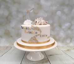 there is a white cake with gold trimmings on the top that says twinkle little