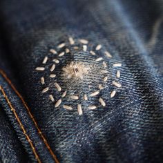 the back pocket of a pair of blue jeans with white sprinkles