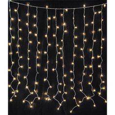 a string of lights hanging from the side of a black wall next to a phone