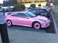 a pink sports car parked in a parking lot